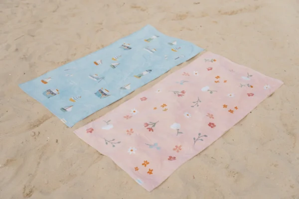 Πετσέτες θαλάσσης απλωμένες σε άμμο με χαριτωμένα σχεδιάκια