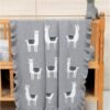 Lama Toy Βρεφική Κουβέρτα Grey με σχέδιο λάμα απλωμένη σε βρεφικό κρεβάτι