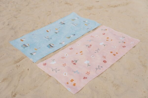 Πετσέτες θαλάσσης μπλε και ροζ με σχεδιάκια απλωμένες στην άμμο παραλίας