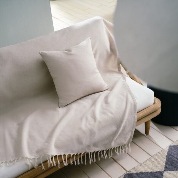 Eartha Ριχτάρι Sail Cloth Beige 372/06 3 Διαστάσεις στρωμένο σε καναπέ με μαξιλάρι